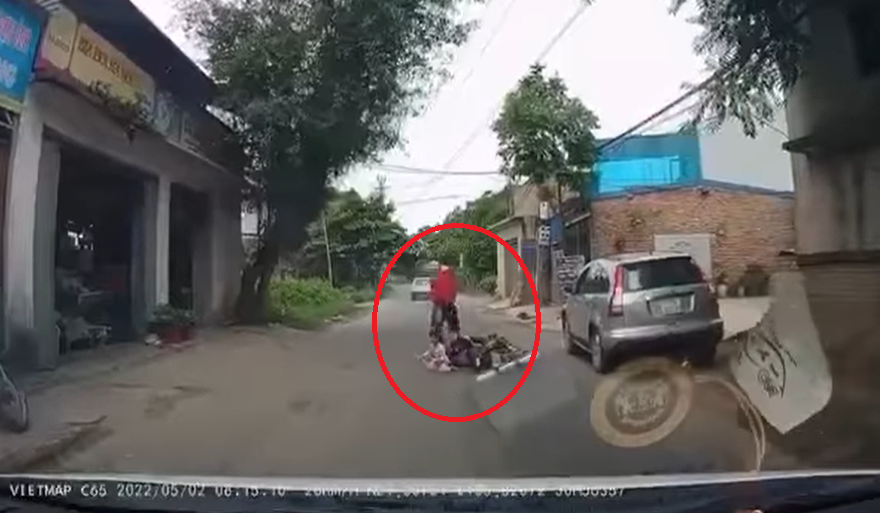 Bất ngờ mở cửa ô tô giữa đường, người phụ nữ khiến 2 bố con đi xe máy ngã nhào