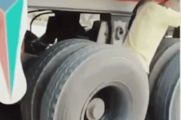Panicked youth roller skates swinging between 2 rows of truck tires