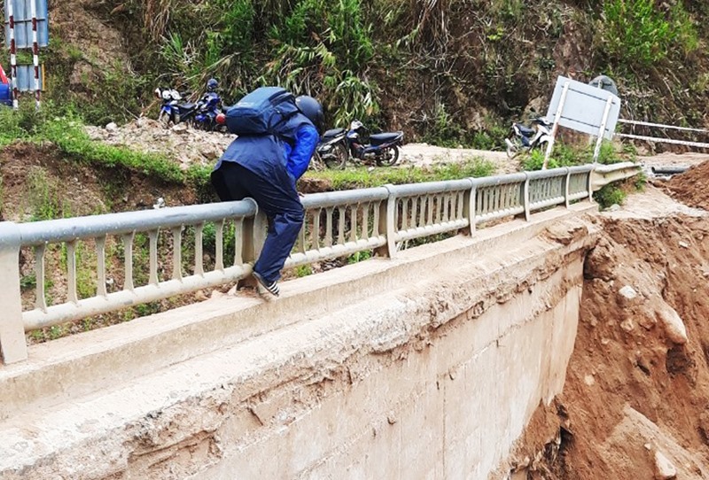 Quang Nam: People risk their lives clinging to the railing to cross the collapsed bridge